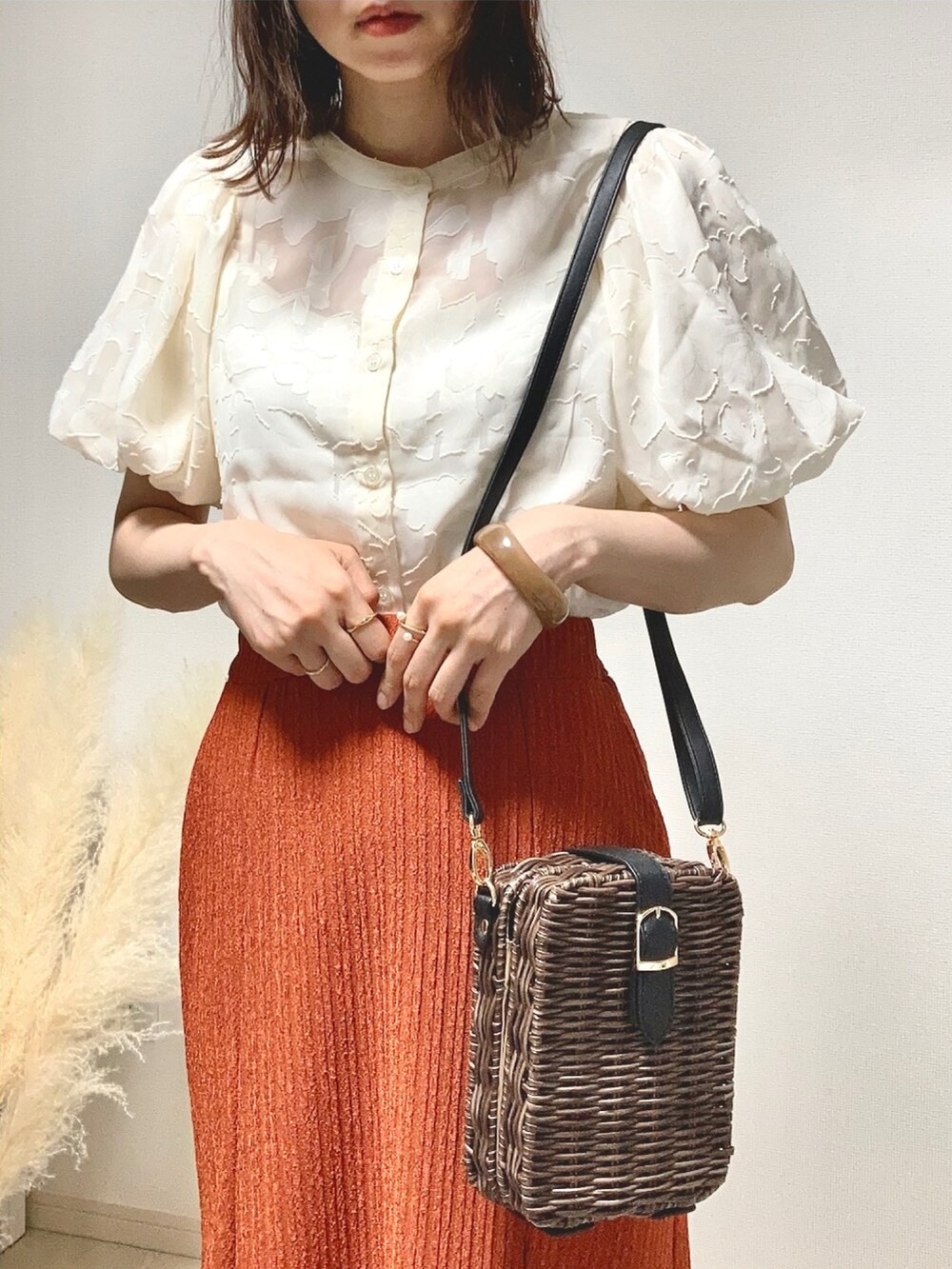 ホワイト系のシャツ/ブラウス、オレンジ系のスカート、ブラウン系のかごバッグを着用したレディースの夏コーディネートの4枚目の写真