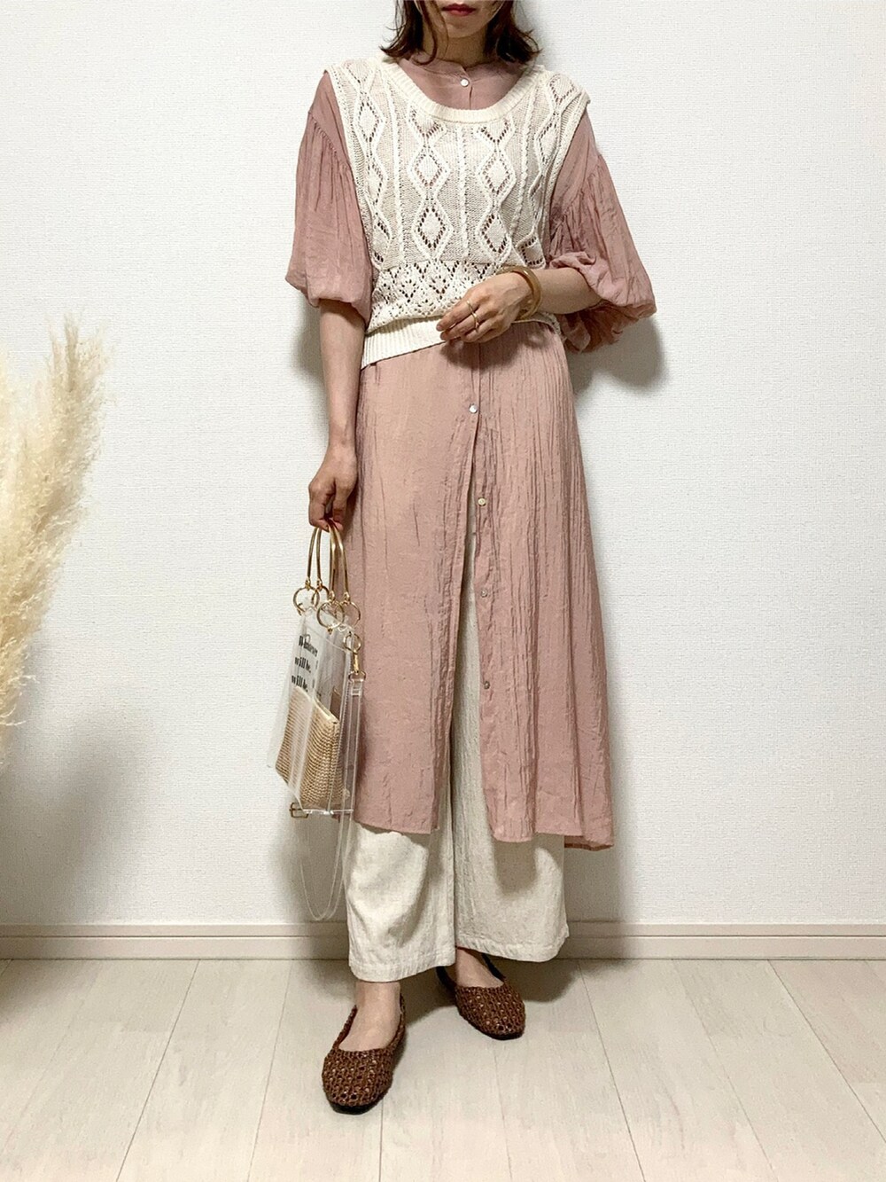 オレンジ系のシャツワンピース、ベージュ系のベスト、ホワイト系のその他パンツを着用したレディースの夏コーディネートの4枚目の写真