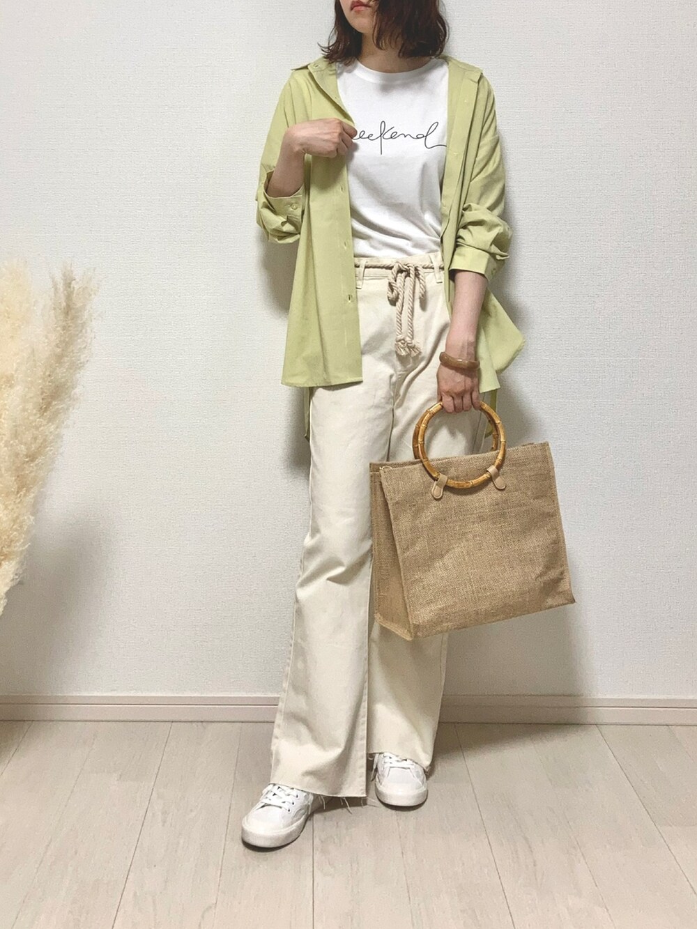 グリーン系のシャツワンピース、ベージュ系のトップス、ホワイト系のデニムパンツを着用したレディースの夏コーディネートの3枚目の写真