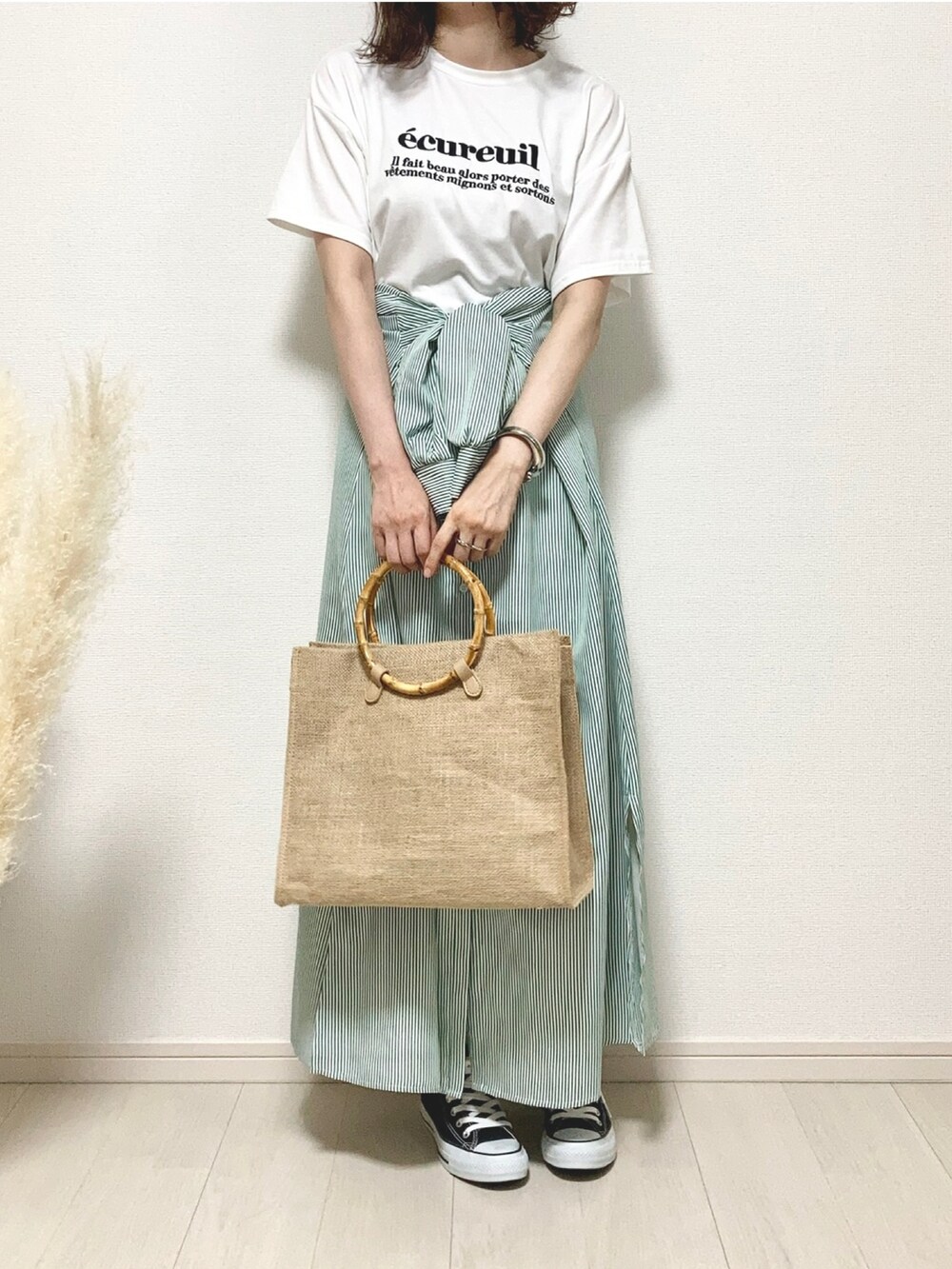 ホワイト系のTシャツ/カットソー、グリーン系のワンピース、ベージュ系のハンドバッグを着用したレディースの夏コーディネートの3枚目の写真