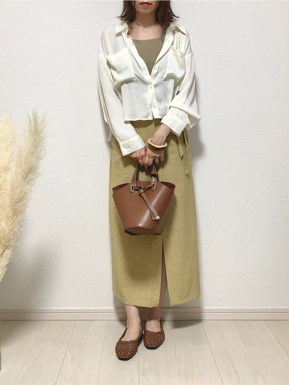 ベージュ系のタンクトップ、ホワイト系のシャツ/ブラウス、イエロー系のスカートを着用したレディースの夏コーディネートの2枚目の写真