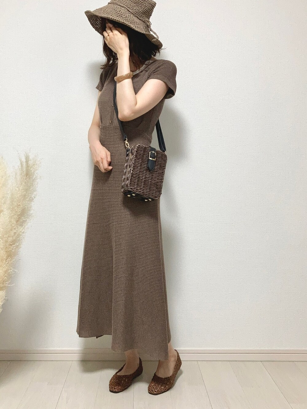 ブラウン系のワンピース、ホワイト系のタンクトップ、ブラウン系のかごバッグを着用したレディースの夏コーディネートの2枚目の写真