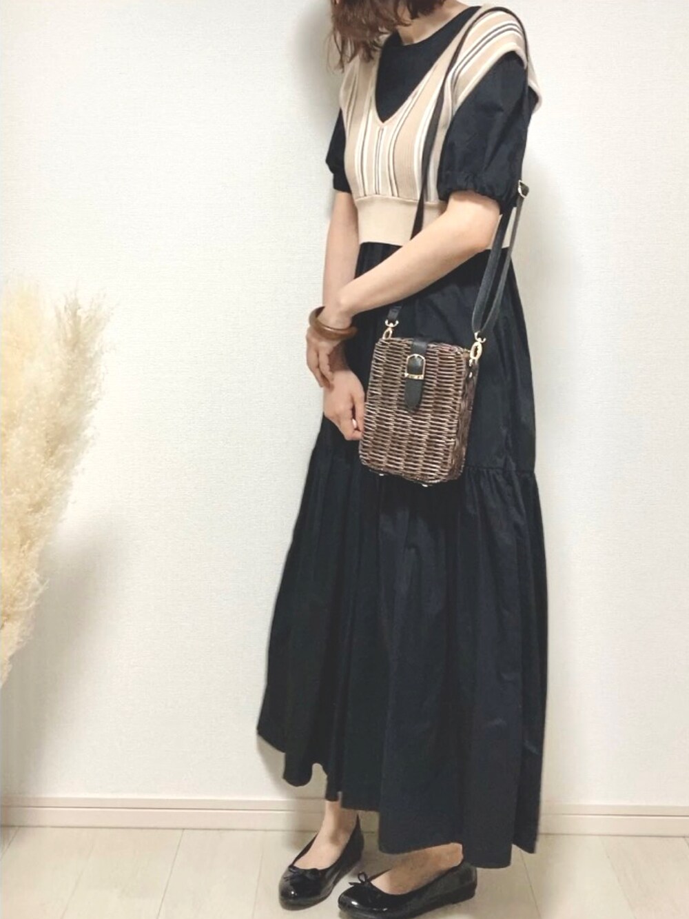 ブラック系のワンピース/ドレス、ベージュ系のベスト、ブラック系のパンプスを着用したレディースの夏コーディネートの2枚目の写真