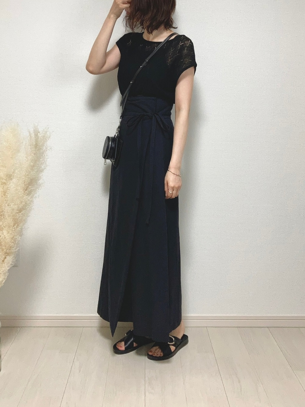 ブラック系のトップス、ブラック系のスカート、ブラック系のサンダルを着用したレディースの夏コーディネートの3枚目の写真
