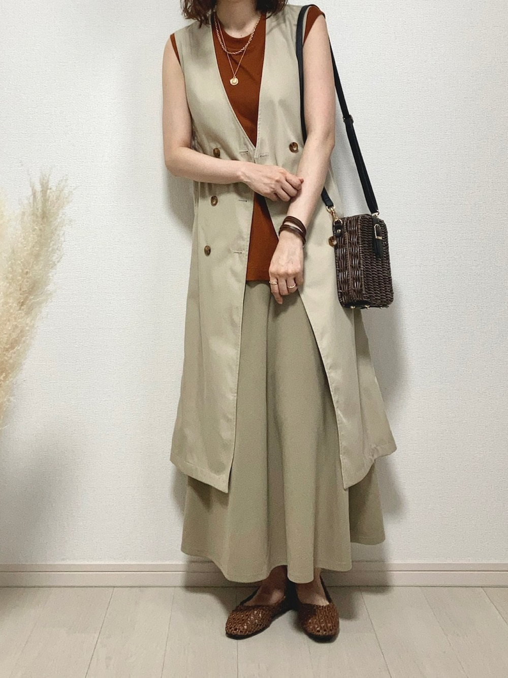 ブラウン系のTシャツ/カットソー、ベージュ系のベスト、ブラウン系のかごバッグを着用したレディースの夏コーディネートの3枚目の写真