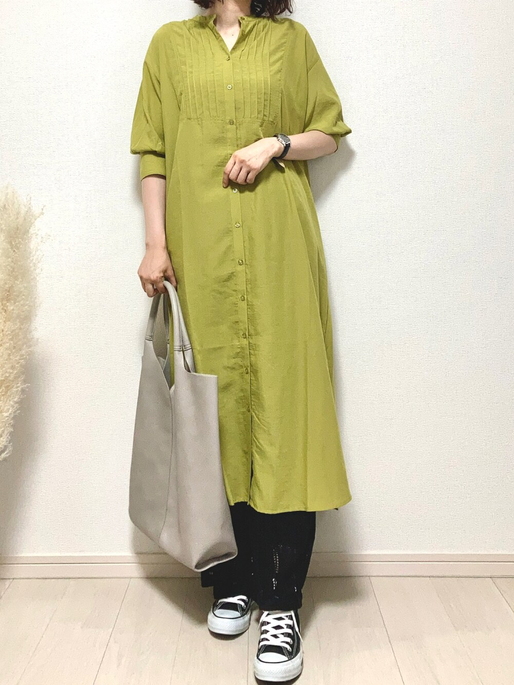 グリーン系のシャツワンピース、ブラック系のアンサンブル、ホワイト系のトートバッグを着用したレディースの夏コーディネートの2枚目の写真