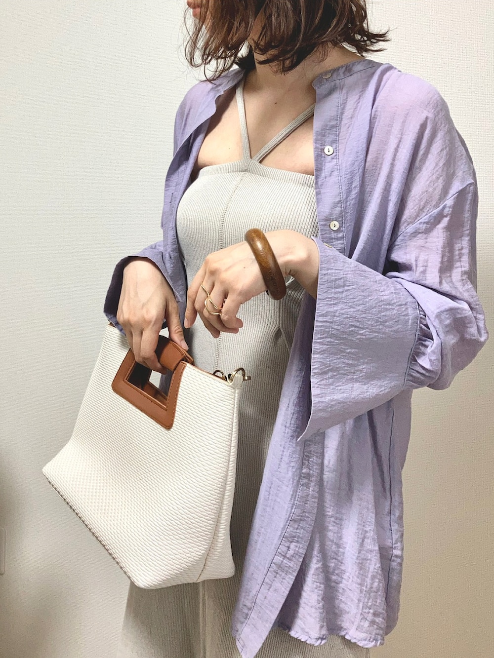 ベージュ系のワンピース、パープル系のシャツ/ブラウス、ホワイト系のハンドバッグを着用したレディースの夏コーディネートの3枚目の写真