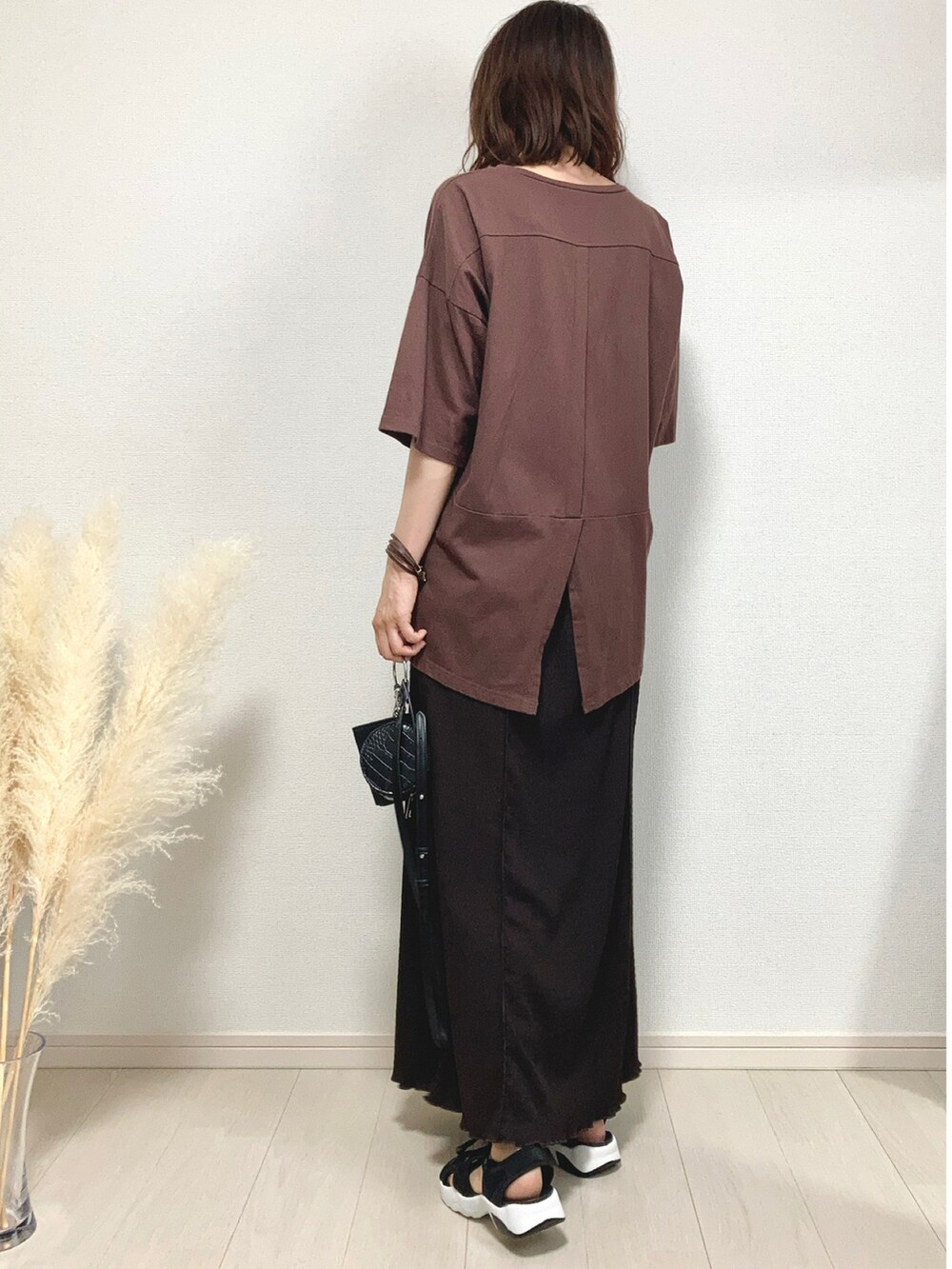 ブラウン系のスカート、ブラック系のサンダル、ブラック系のショルダーバッグを着用したレディースの夏コーディネートの2枚目の写真