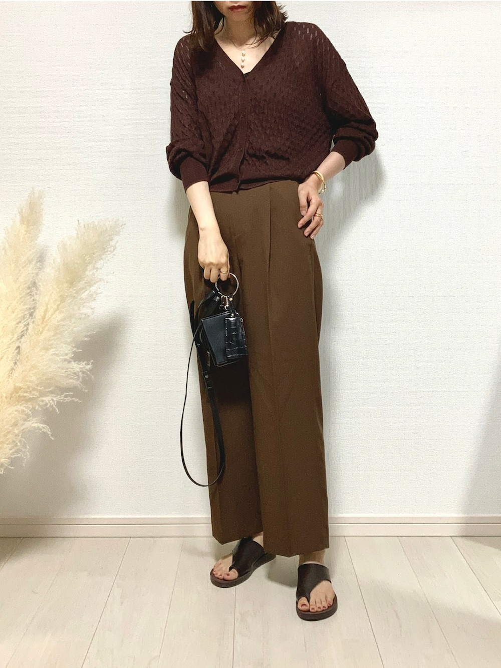 ブラウン系のニット/セーター、ブラウン系のスラックス、ブラウン系のサンダルを着用したレディースの夏コーディネートの3枚目の写真