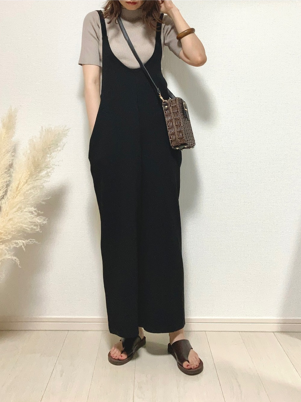 ブラック系のつなぎ/オールインワン、グレー系のニット/セーター、ブラウン系のサンダルを着用したレディースの夏コーディネートの2枚目の写真
