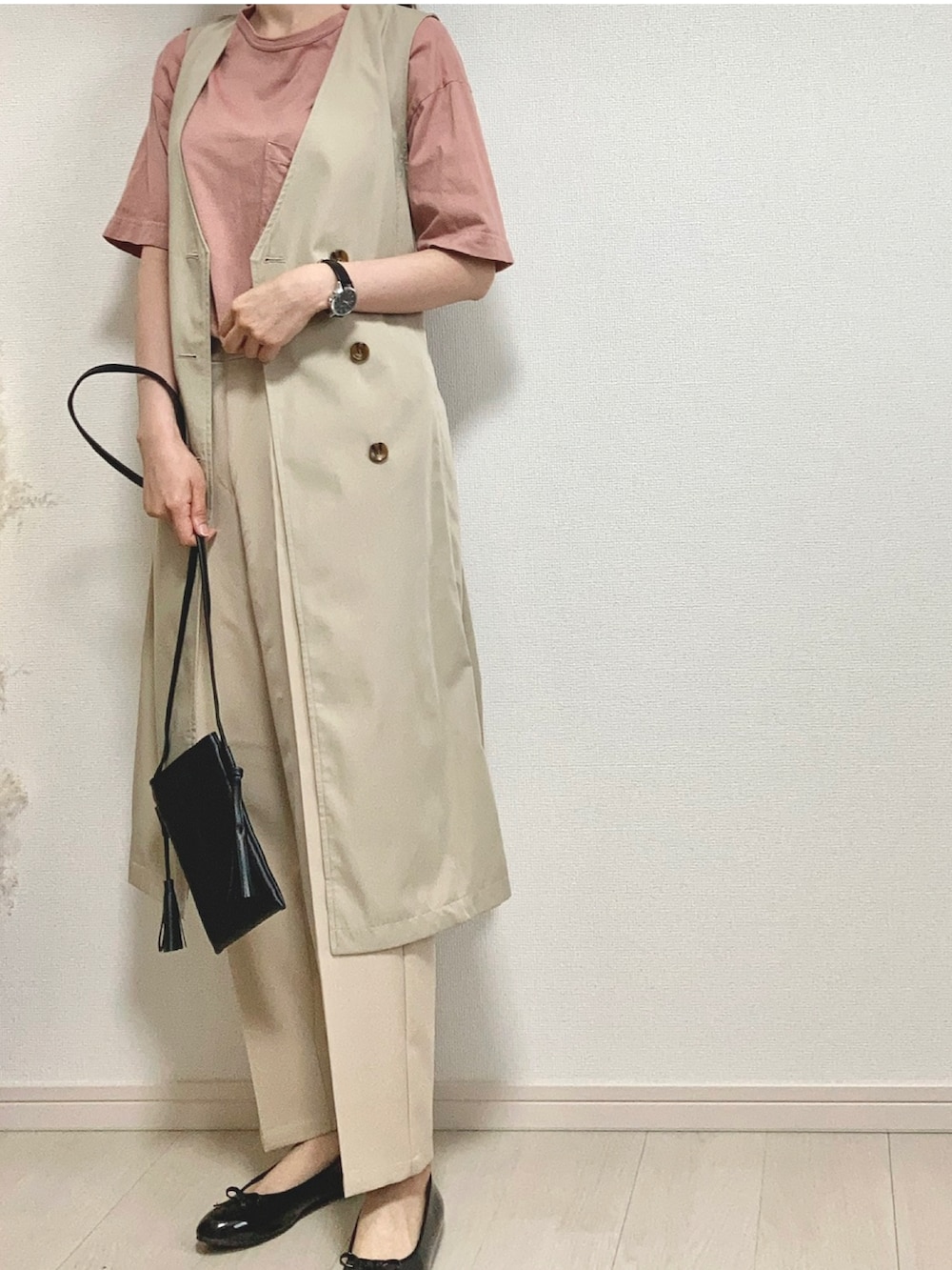 ピンク系のTシャツ/カットソー、ベージュ系のベスト、ベージュ系のパンツを着用したレディースの春コーディネートの2枚目の写真