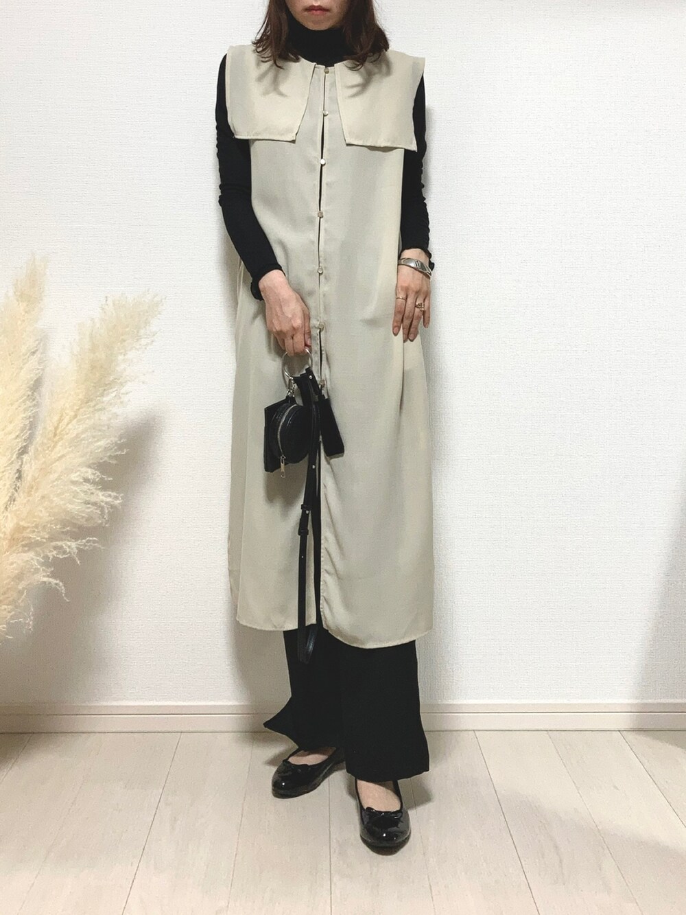 ブラック系のTシャツ/カットソー、ベージュ系のトップス、ブラック系のパンプスを着用したレディースの秋コーディネートの3枚目の写真