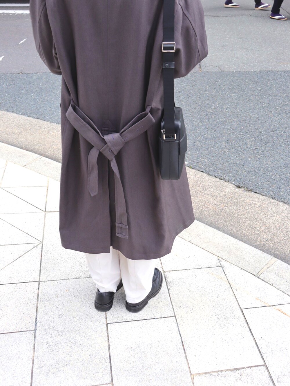 ブラック系のドレスシューズ、ホワイト系のその他パンツ、グレー系のトレンチコートを着用したメンズの冬コーディネートの3枚目の写真