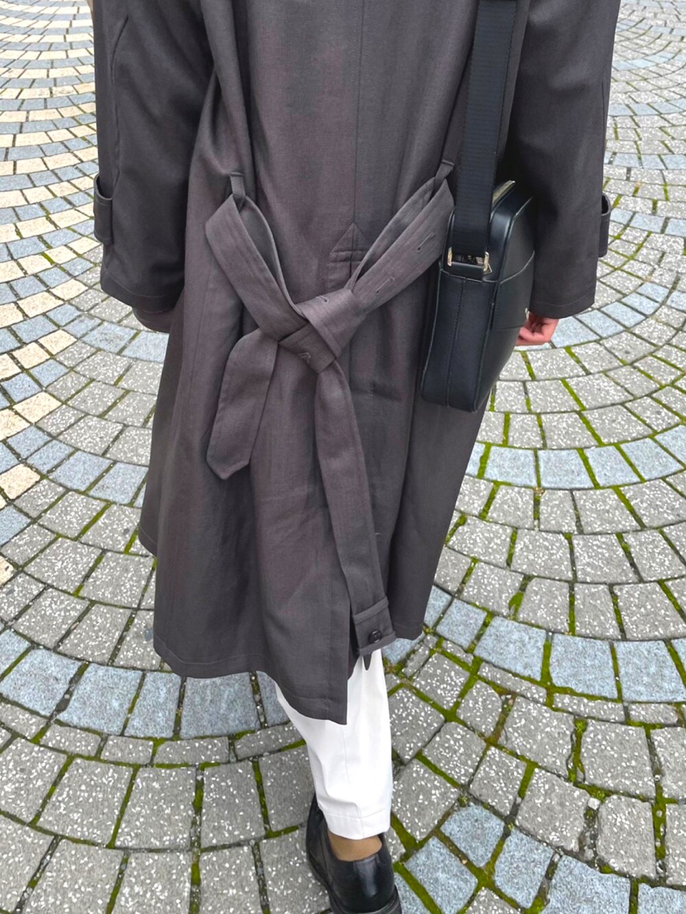 ブラック系のドレスシューズ、ホワイト系のその他パンツ、グレー系のトレンチコートを着用したメンズの冬コーディネートの2枚目の写真