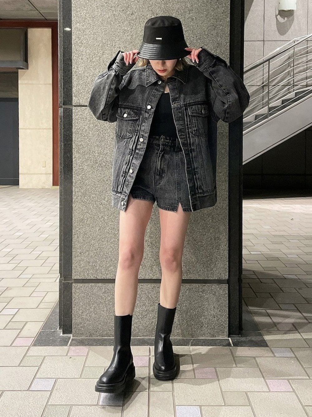 ブラック系のデニムジャケット、ブラック系のTシャツ/カットソー、ブラック系のブーツを着用したレディースの春コーディネートの2枚目の写真