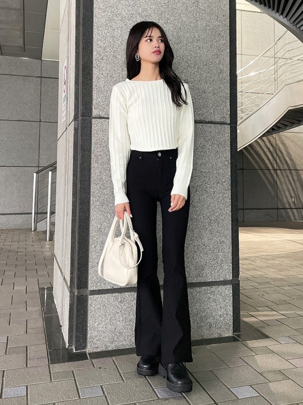 ホワイト系のニット/セーター、ブラック系のその他パンツ、ホワイト系のショルダーバッグを着用したレディースの冬コーディネートの2枚目の写真