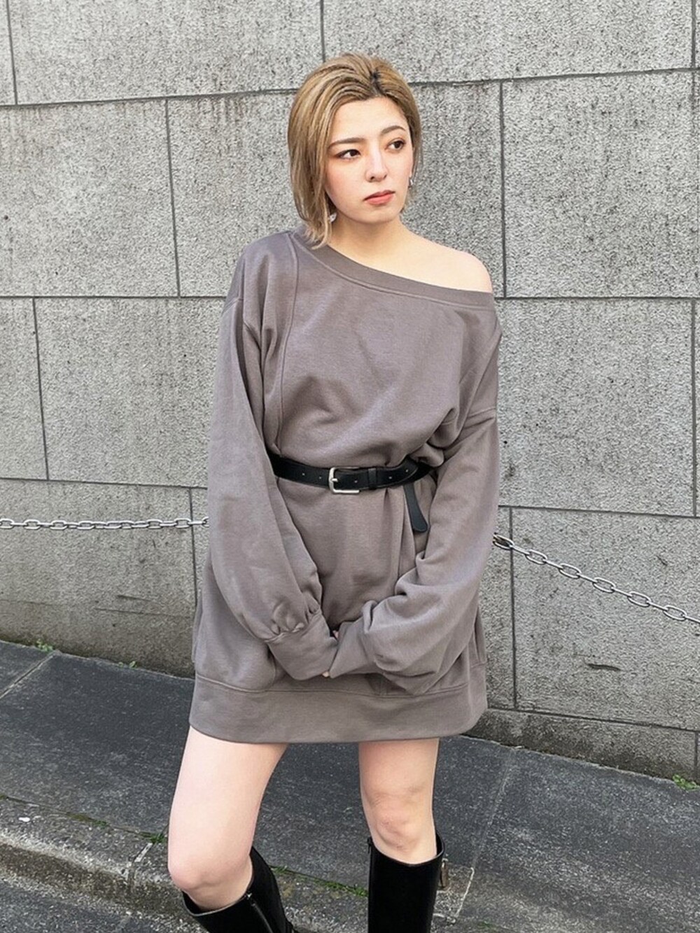 ブラック系のワンピース、ブラック系のブーツを着用したレディースの春コーディネートの2枚目の写真