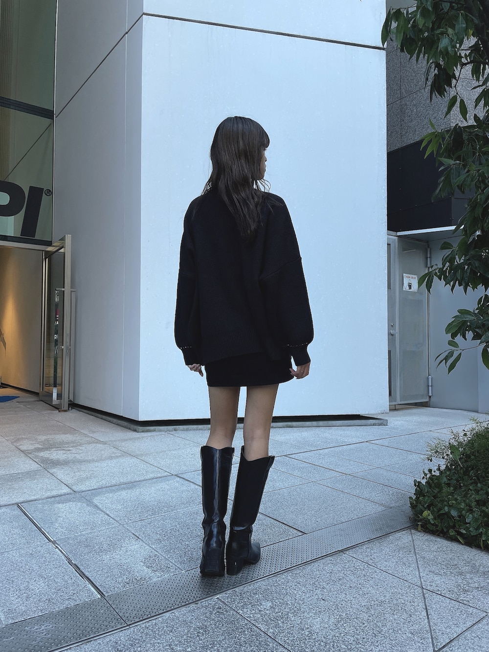 ブラック系のカーディガン/ボレロ、ブラック系のTシャツ/カットソー、ブラック系のブーツを着用したレディースの冬コーディネートの2枚目の写真