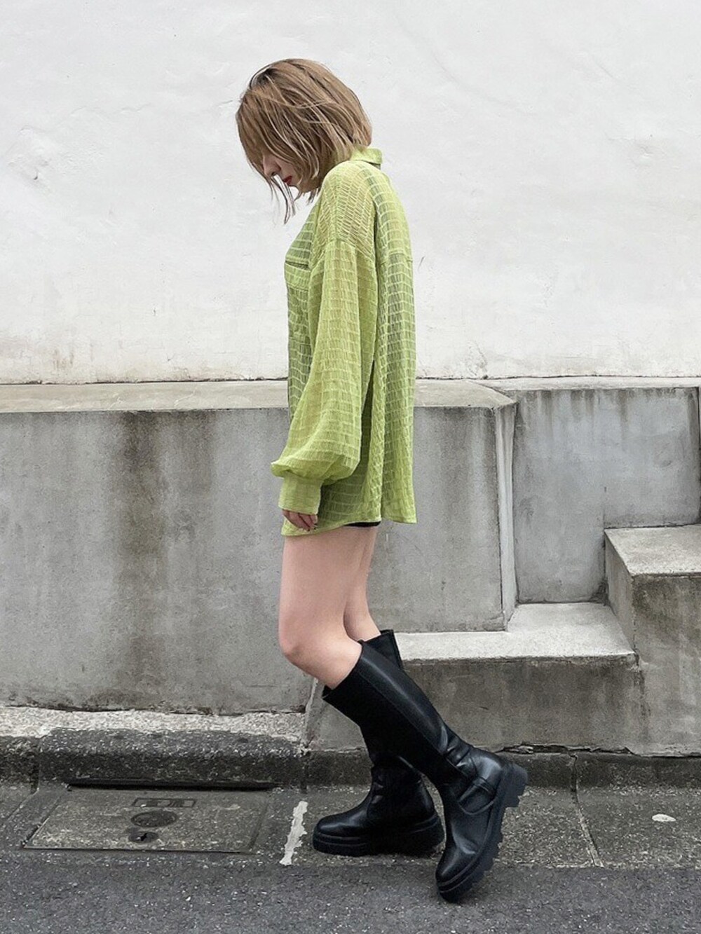 グリーン系のシャツ/ブラウス、ブラック系のブーツを着用したレディースの春コーディネートの2枚目の写真