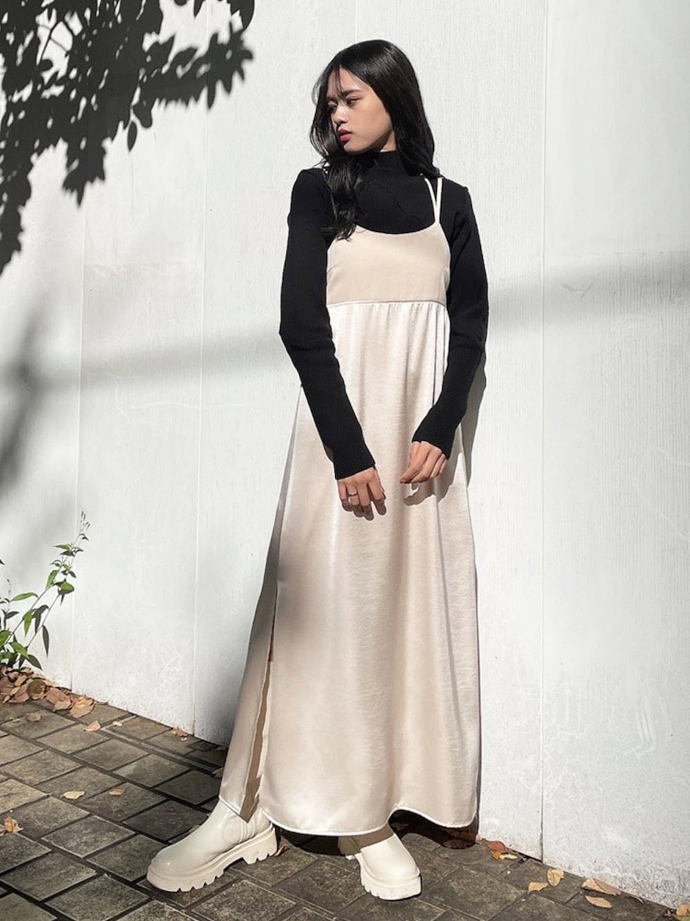 ブラック系のワンピース、グレー系のニット/セーター、ブラック系のブーツを着用したレディースの冬コーディネートの2枚目の写真