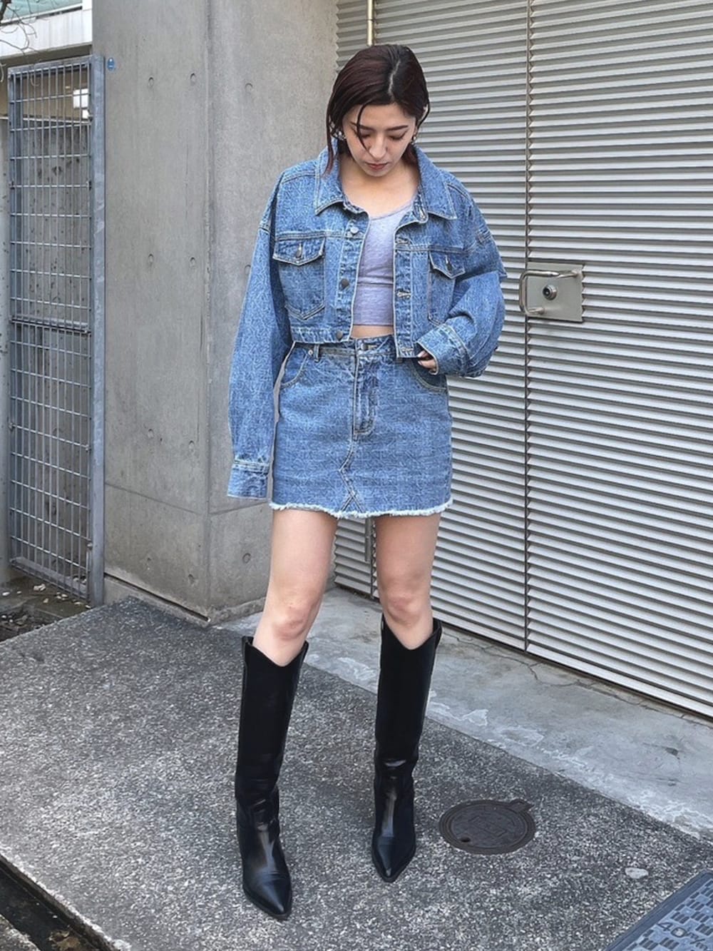 ブルー系のその他アウター、ブルー系のスカート、ブラック系のブーツを着用したレディースの春コーディネートの2枚目の写真