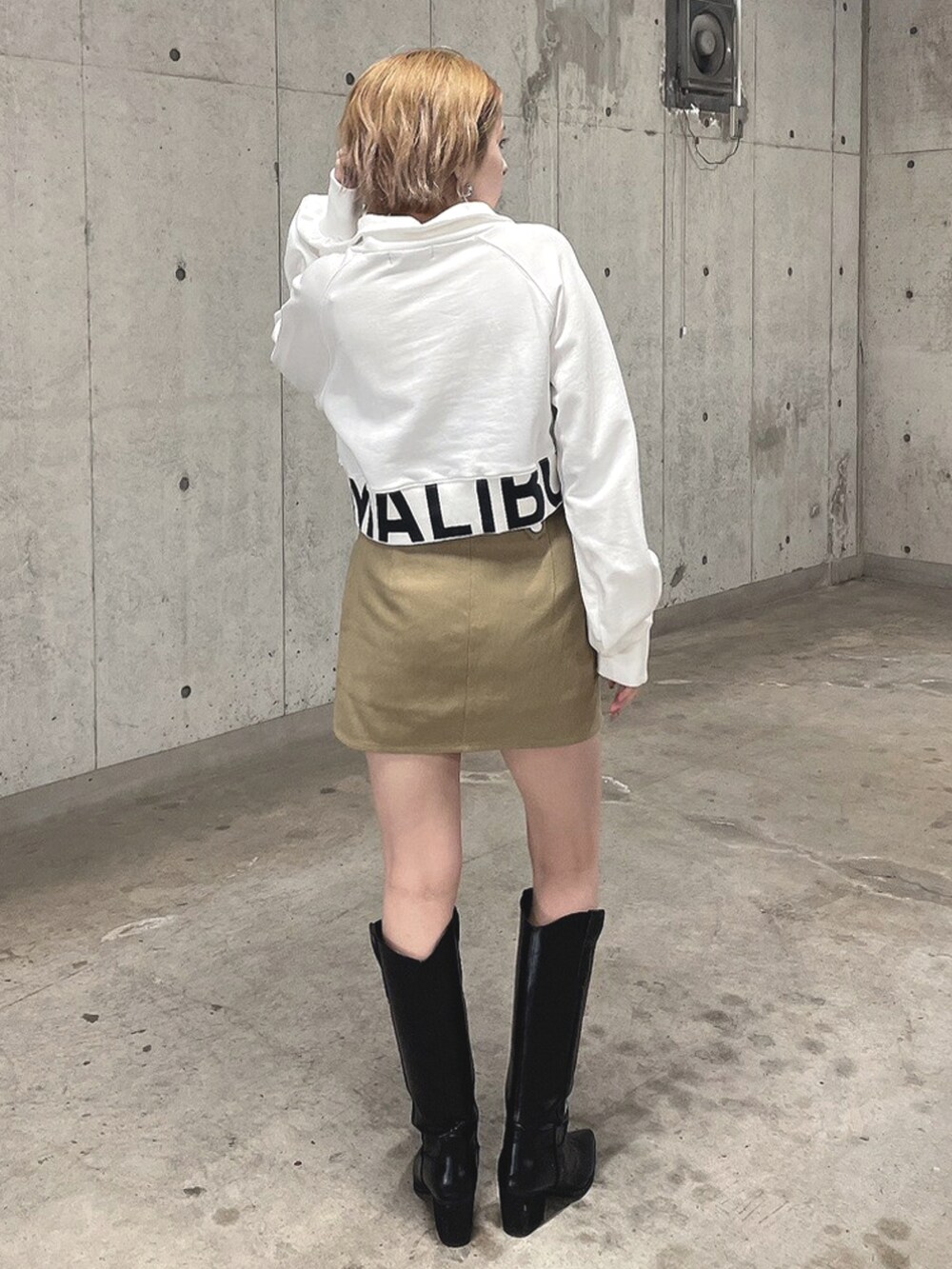 ホワイト系のTシャツ/カットソー、ベージュ系のスカート、ブラック系のブーツを着用したレディースの春コーディネートの3枚目の写真