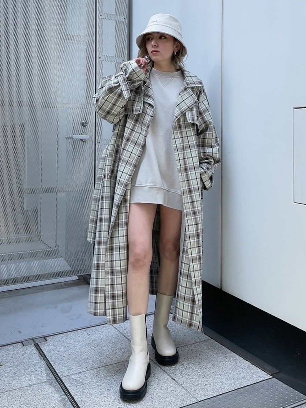 その他のトレンチコート、ホワイト系のブーツ、グレー系のスラックスを着用したレディースの冬コーディネートの3枚目の写真