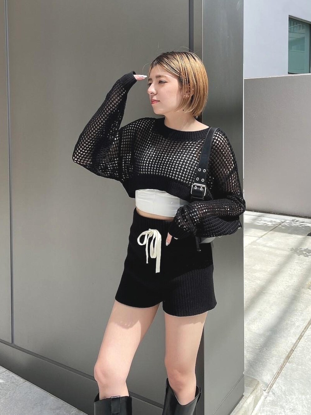 ブラック系のニット/セーター、ブラック系のその他パンツ、ブラック系のブーツを着用したレディースの春コーディネートの3枚目の写真