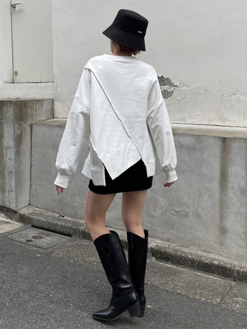 ホワイト系のTシャツ/カットソー、ブラック系のブーツ、ブラック系のハットを着用したレディースの冬コーディネートの3枚目の写真