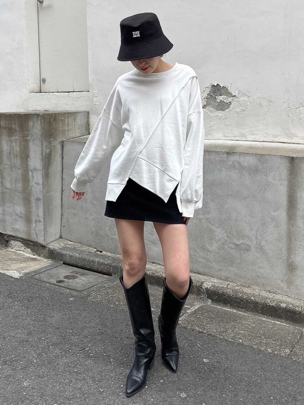 ホワイト系のTシャツ/カットソー、ブラック系のブーツ、ブラック系のハットを着用したレディースの冬コーディネートの2枚目の写真