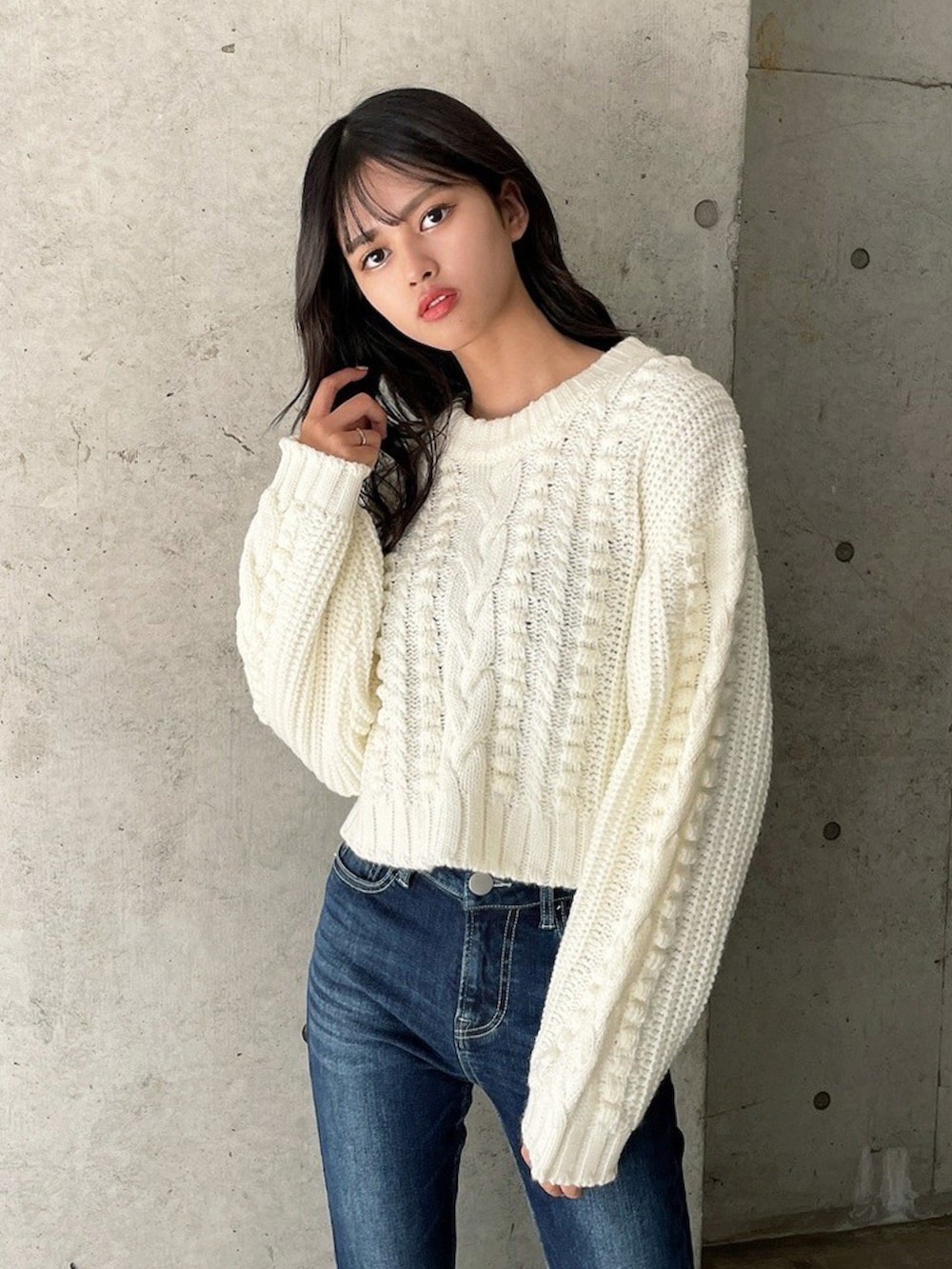 ホワイト系のニット/セーター、ブルー系のデニムパンツを着用したレディースの冬コーディネートの2枚目の写真