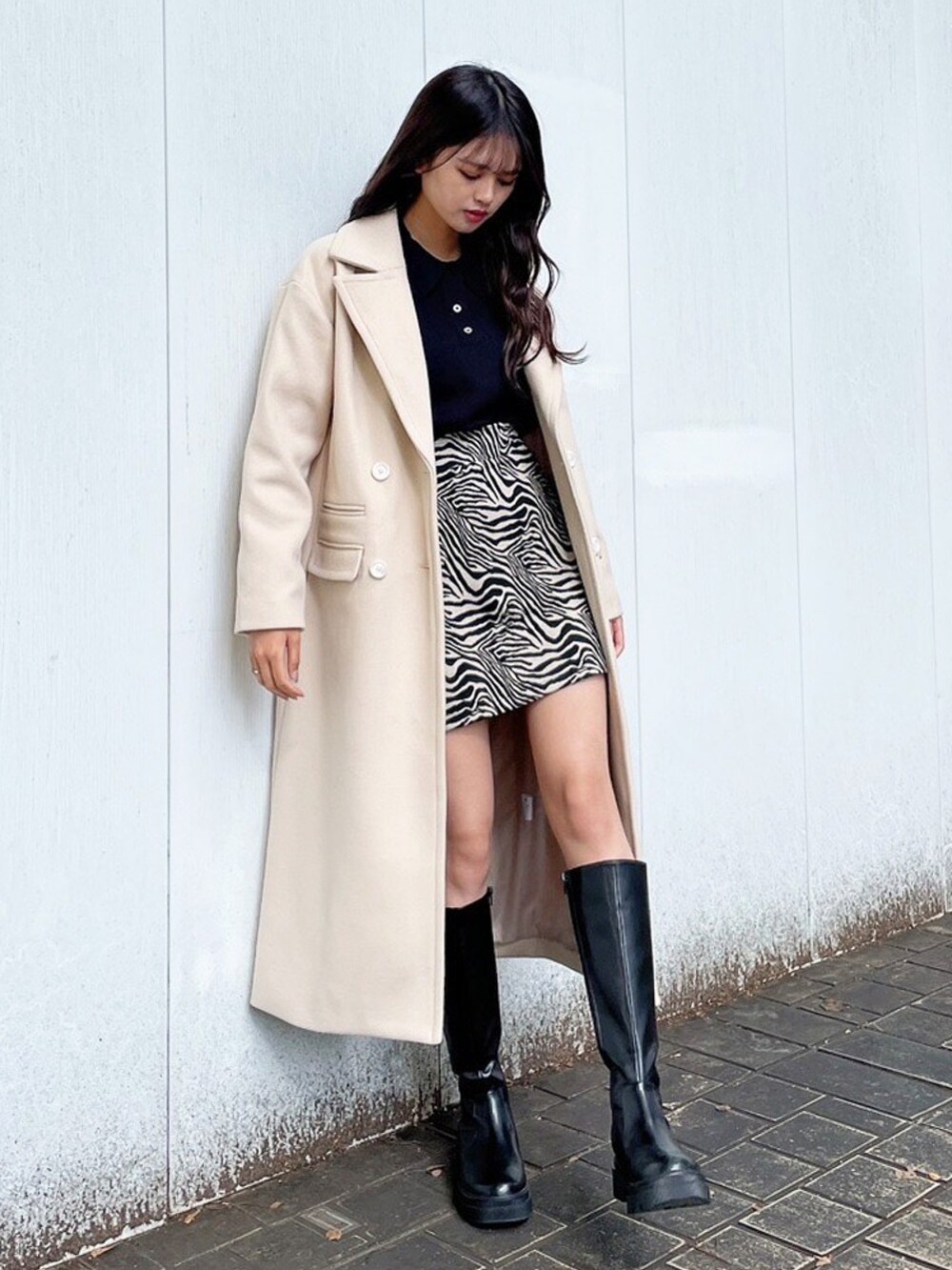 ブラック系のニット/セーター、ベージュ系のスカート、ブラック系のその他アウターを着用したレディースの冬コーディネートの2枚目の写真