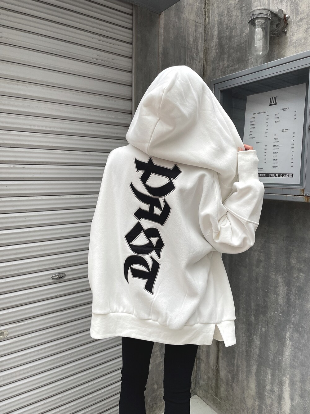 ホワイト系のパーカー、ブルー系のタンクトップ、ブラック系のその他パンツを着用したレディースの春コーディネートの3枚目の写真