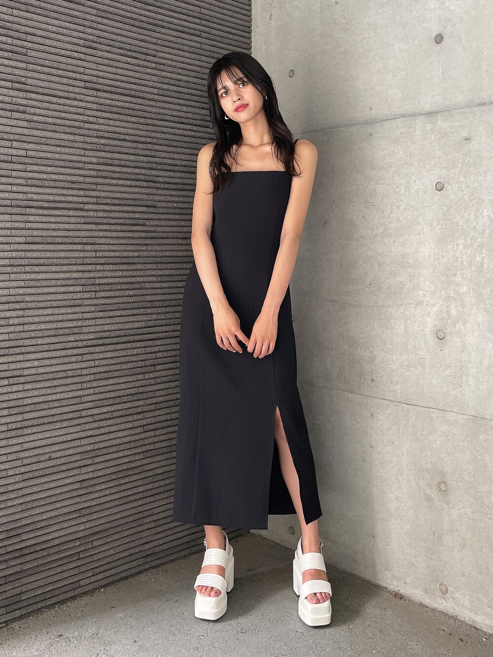 ブラック系のワンピース、ホワイト系のサンダル、ブラウン系のTシャツ/カットソーを着用したレディースの夏コーディネートの2枚目の写真