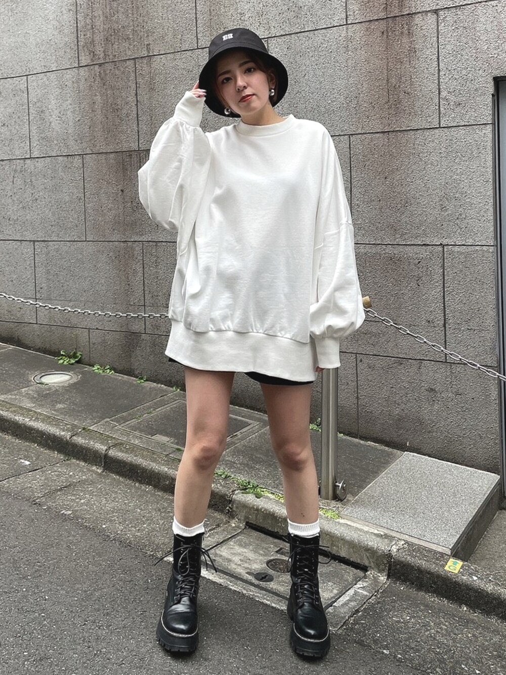 ホワイト系のTシャツ/カットソー、ブラック系のブーツ、ブラック系のハットを着用したレディースの春コーディネートの4枚目の写真