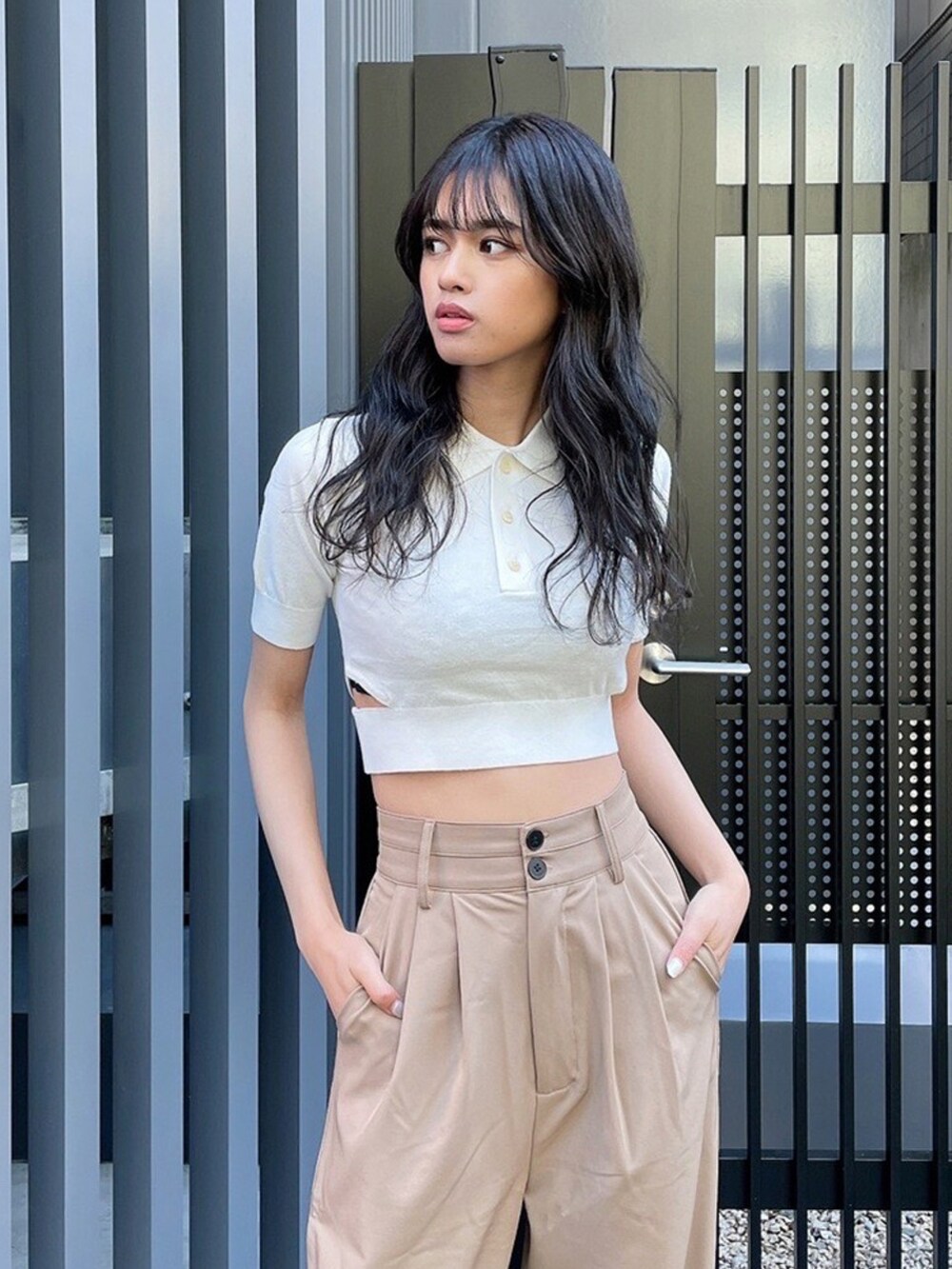 ベージュ系のスラックス、ホワイト系のニット/セーター、ブラック系のブーツを着用したレディースの春コーディネートの2枚目の写真