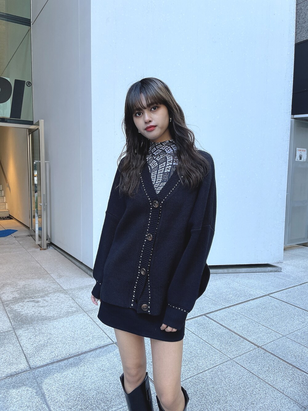ブラック系のカーディガン/ボレロ、ブラック系のTシャツ/カットソー、ブラック系のブーツを着用したレディースの冬コーディネートの3枚目の写真