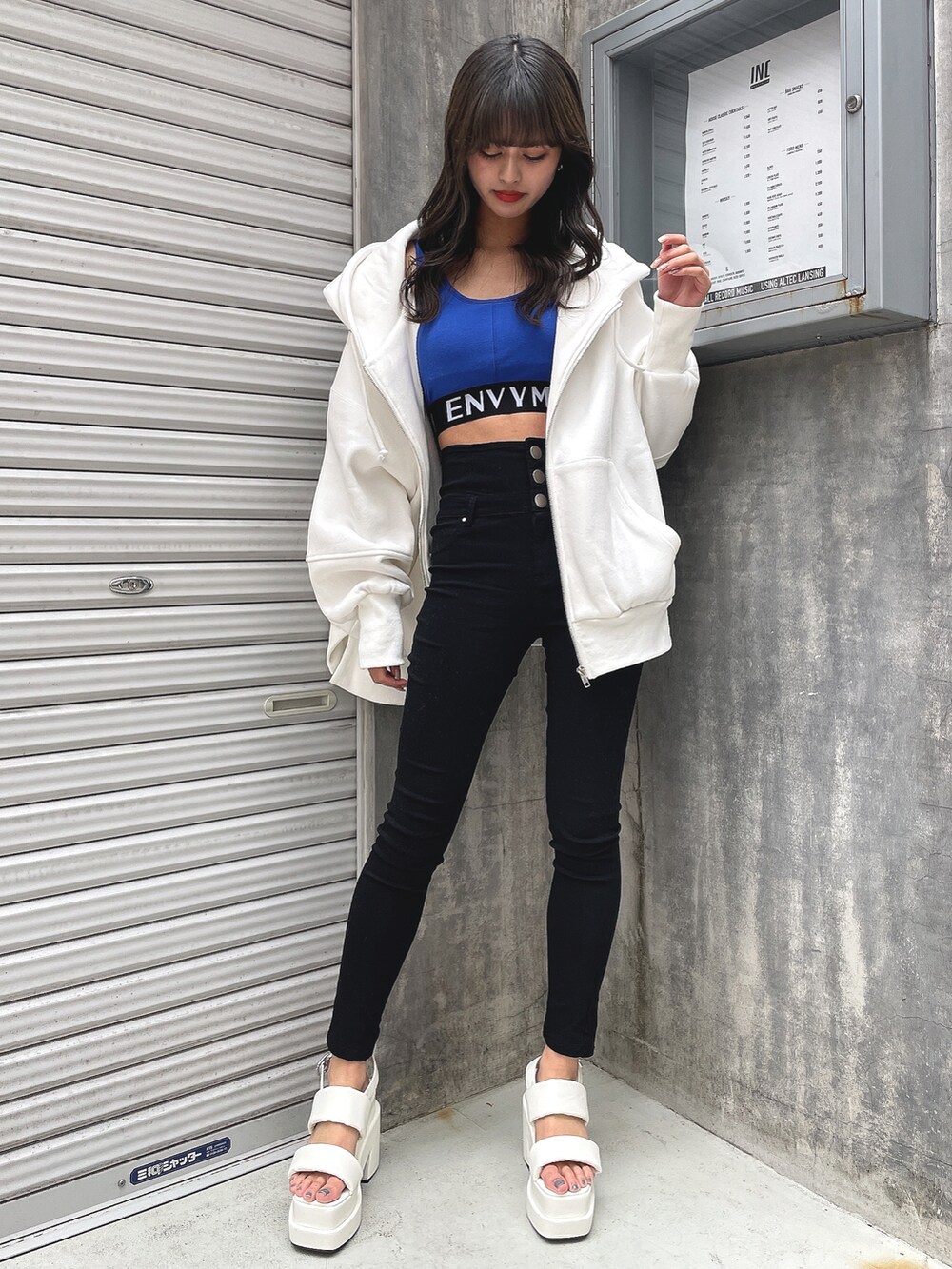 ホワイト系のパーカー、ブルー系のタンクトップ、ブラック系のその他パンツを着用したレディースの春コーディネートの2枚目の写真