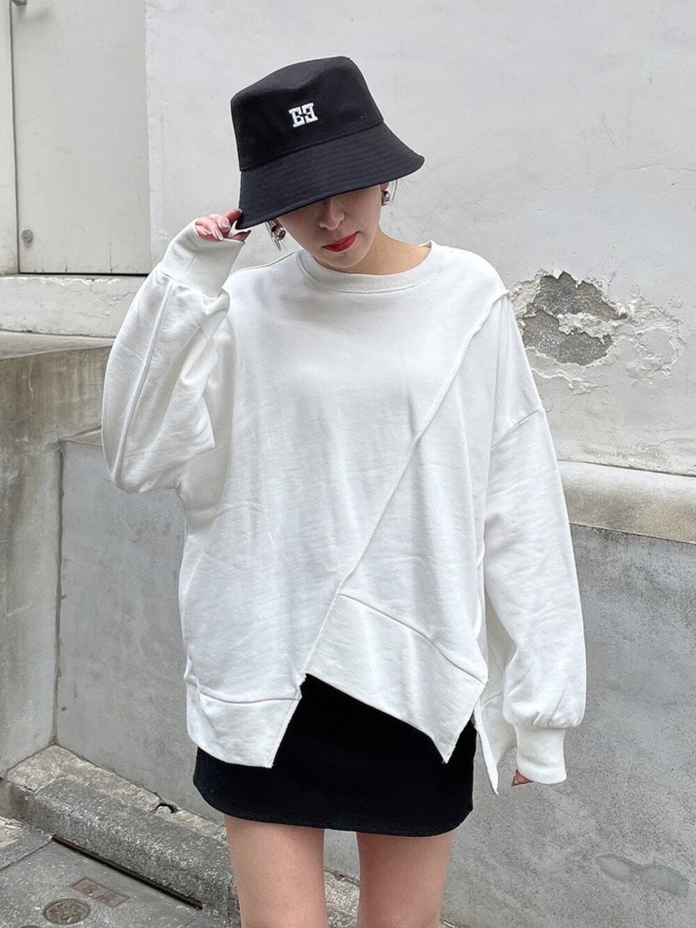 ホワイト系のTシャツ/カットソー、ブラック系のブーツ、ブラック系のハットを着用したレディースの冬コーディネートの5枚目の写真
