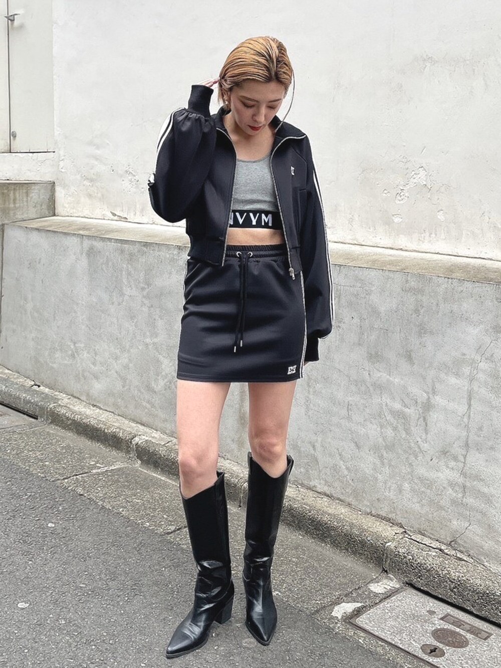 ブラック系のブルゾン、ブラック系のスカート、ブラック系のブーツを着用したレディースの春コーディネートの2枚目の写真
