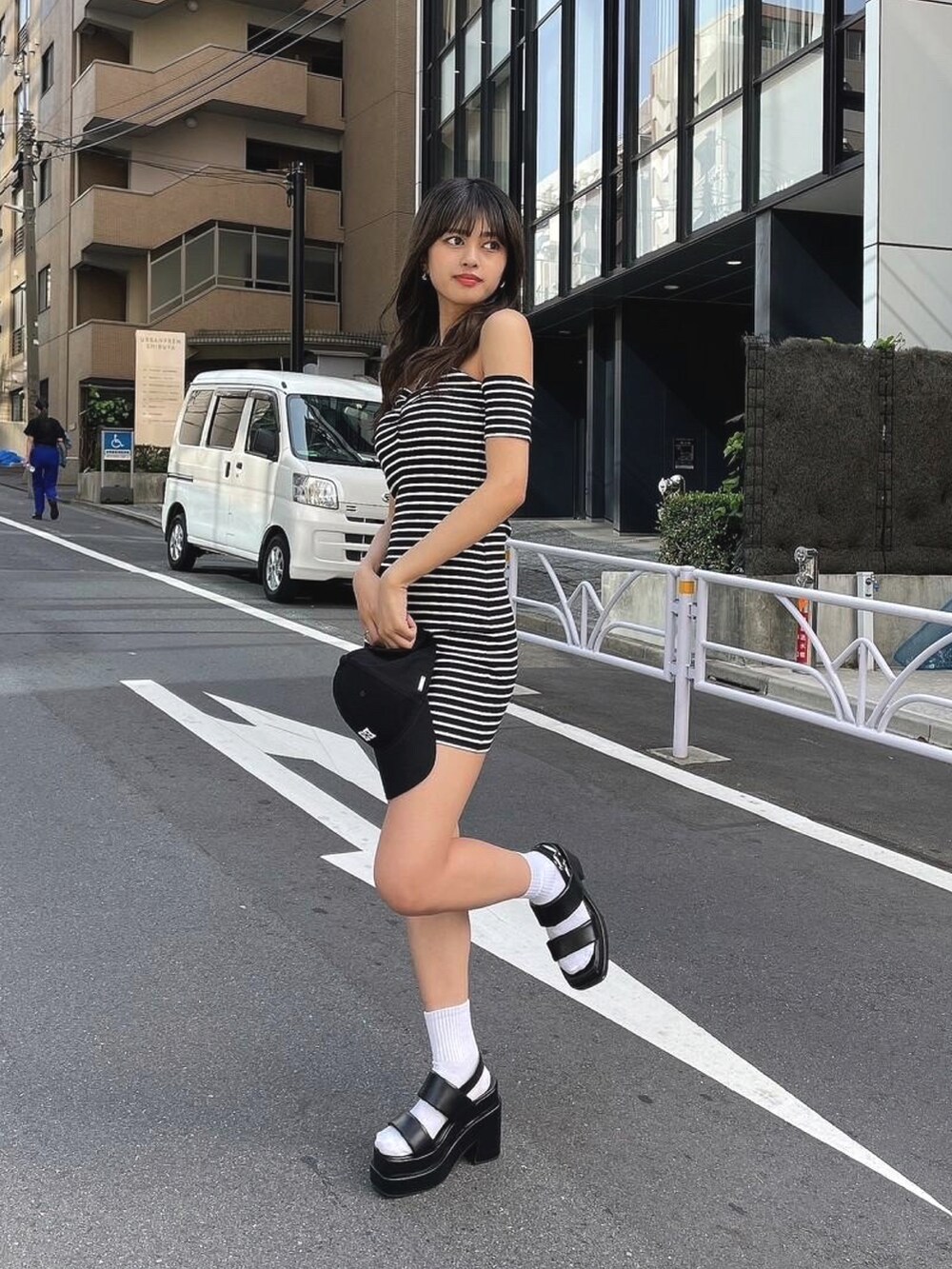 ブラック系のワンピース、ブラック系のサンダル、ブラック系のキャップを着用したレディースの春コーディネートの2枚目の写真