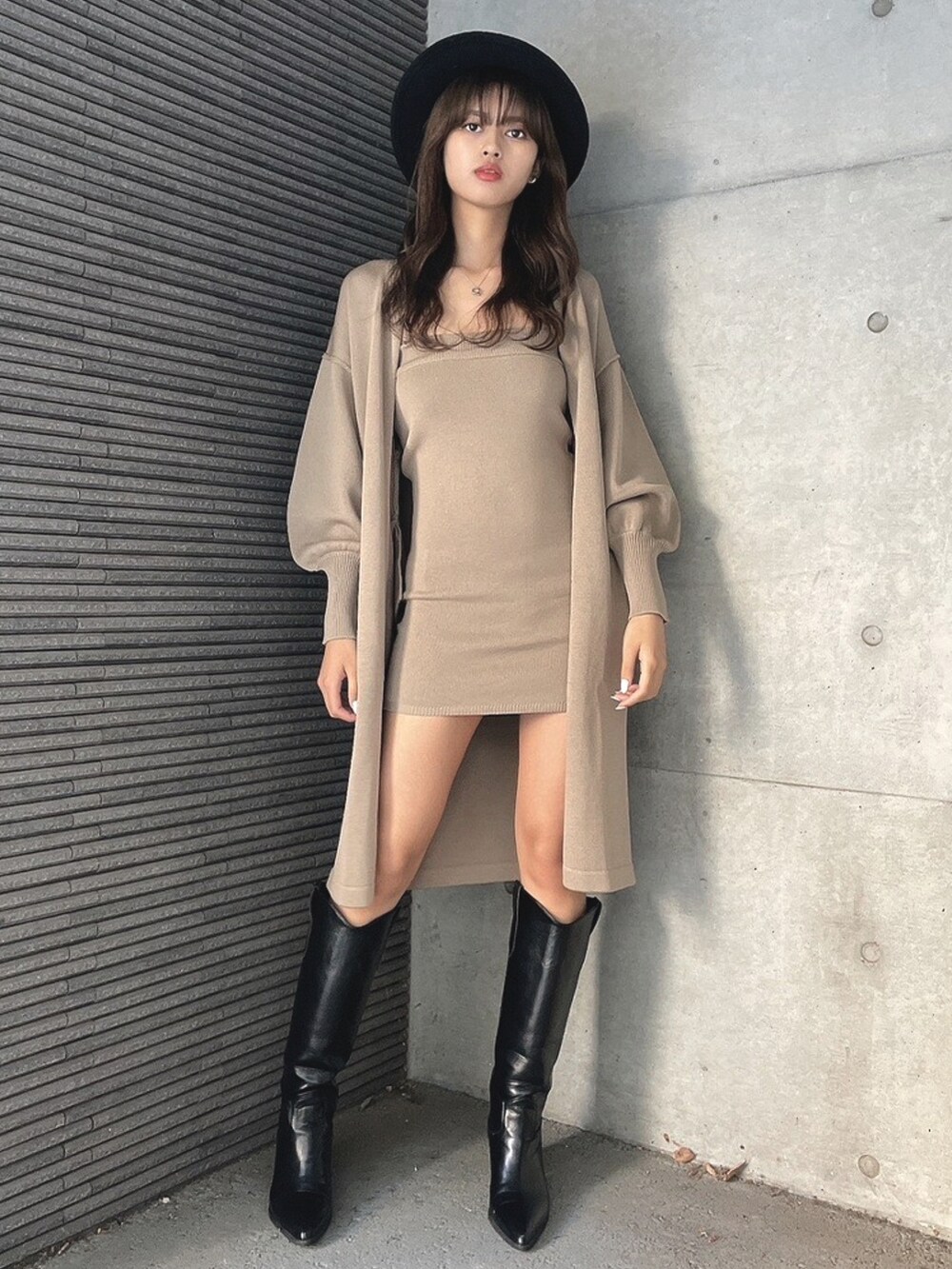 ベージュ系のカーディガン/ボレロ、ベージュ系のワンピース、ブラック系のブーツを着用したレディースの春コーディネートの2枚目の写真