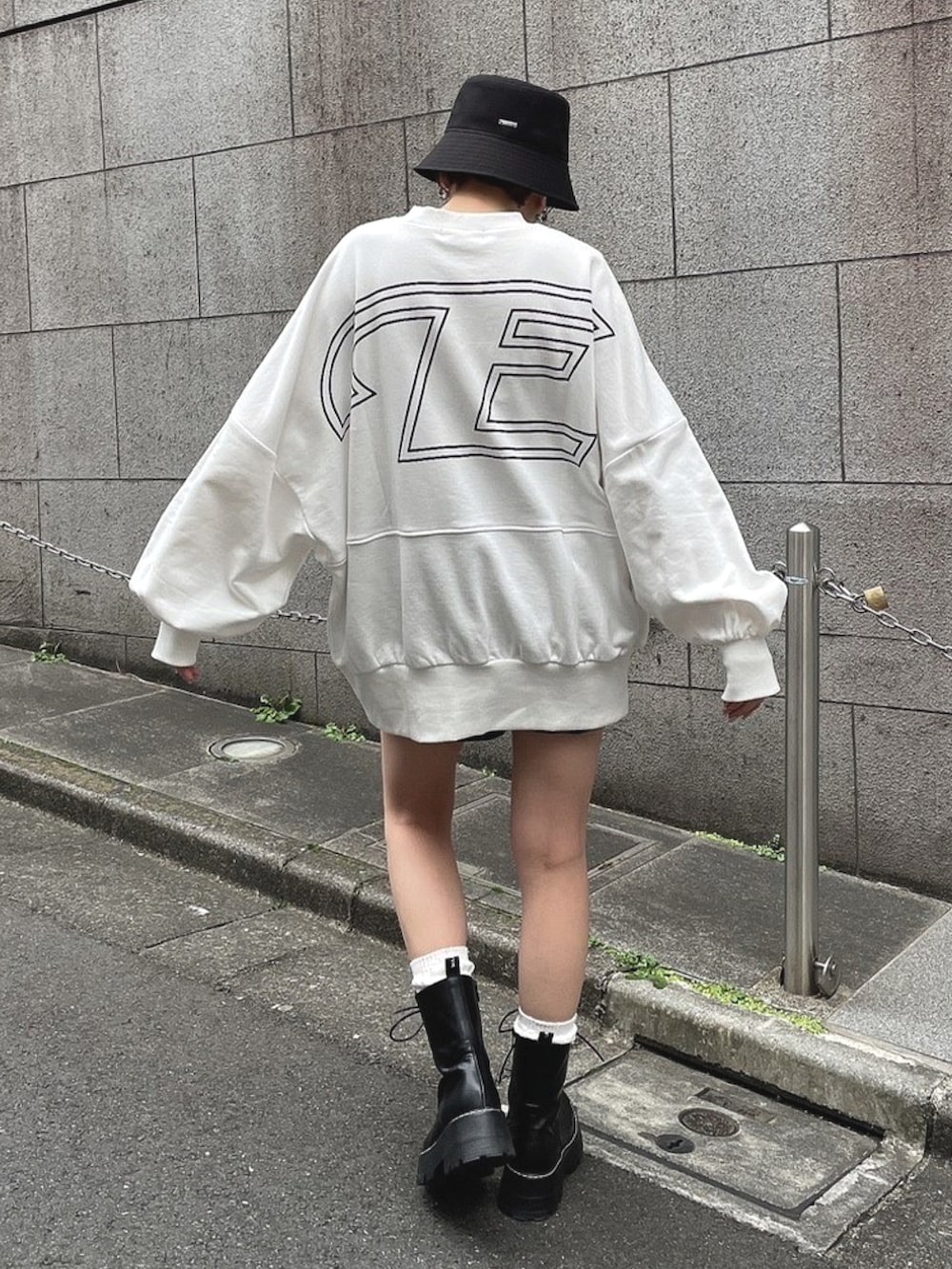 ホワイト系のTシャツ/カットソー、ブラック系のブーツ、ブラック系のハットを着用したレディースの春コーディネートの3枚目の写真