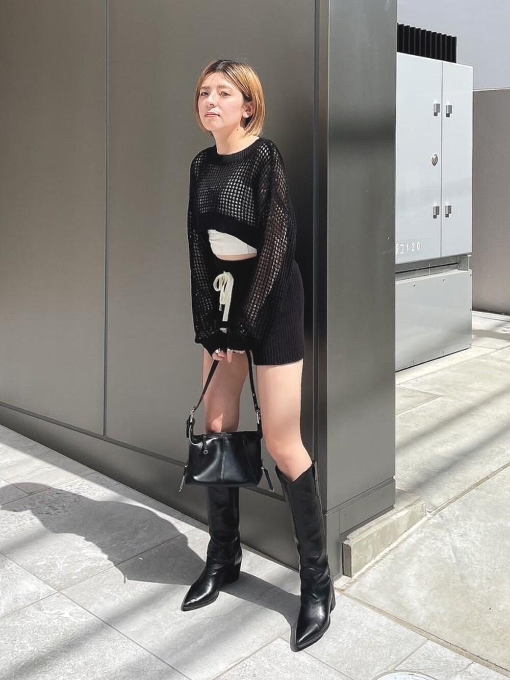 ブラック系のニット/セーター、ブラック系のその他パンツ、ブラック系のブーツを着用したレディースの春コーディネートの2枚目の写真