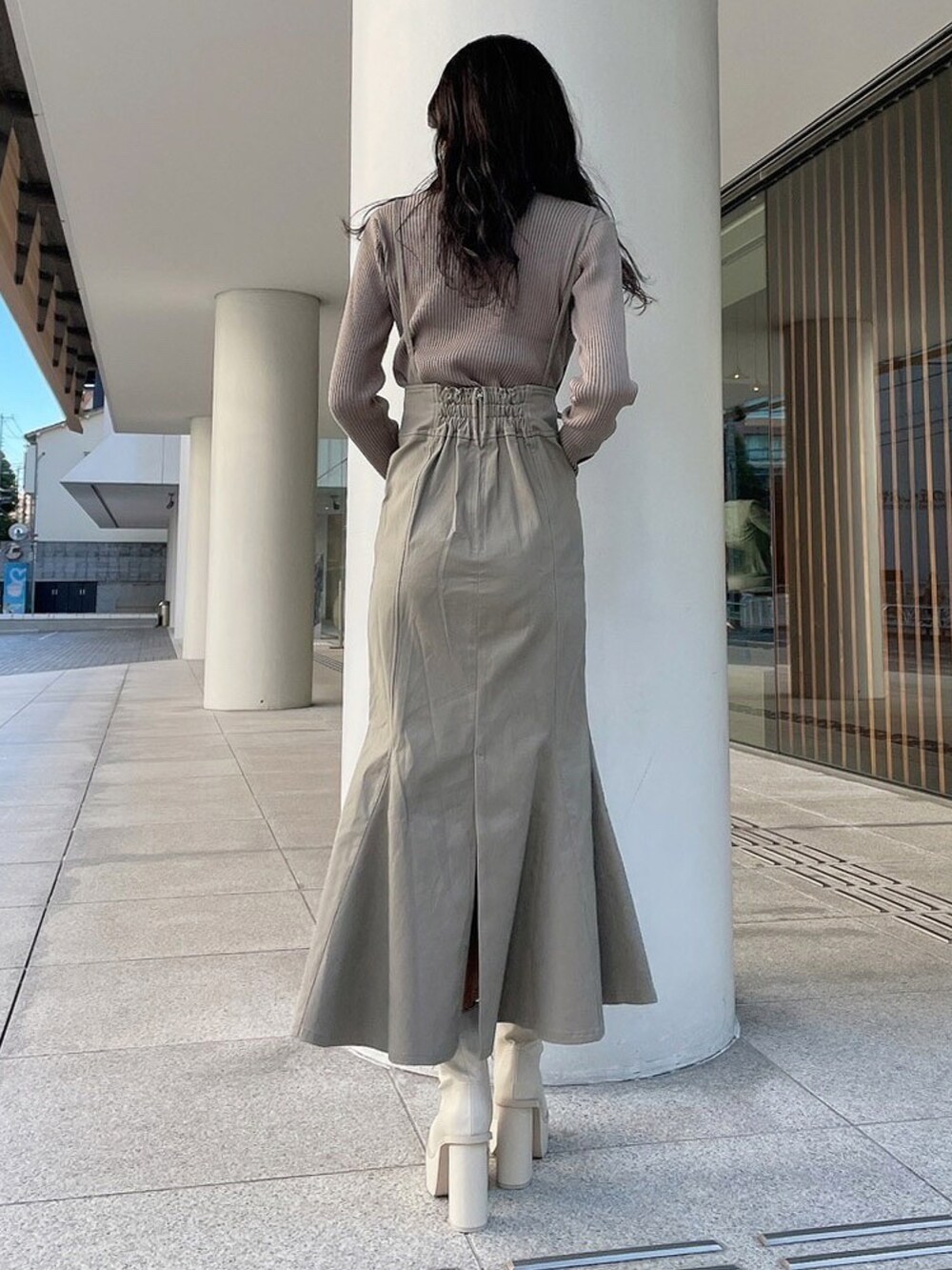 ベージュ系のニット/セーター、ベージュ系のスカート、ホワイト系のブーツを着用したレディースの冬コーディネートの2枚目の写真