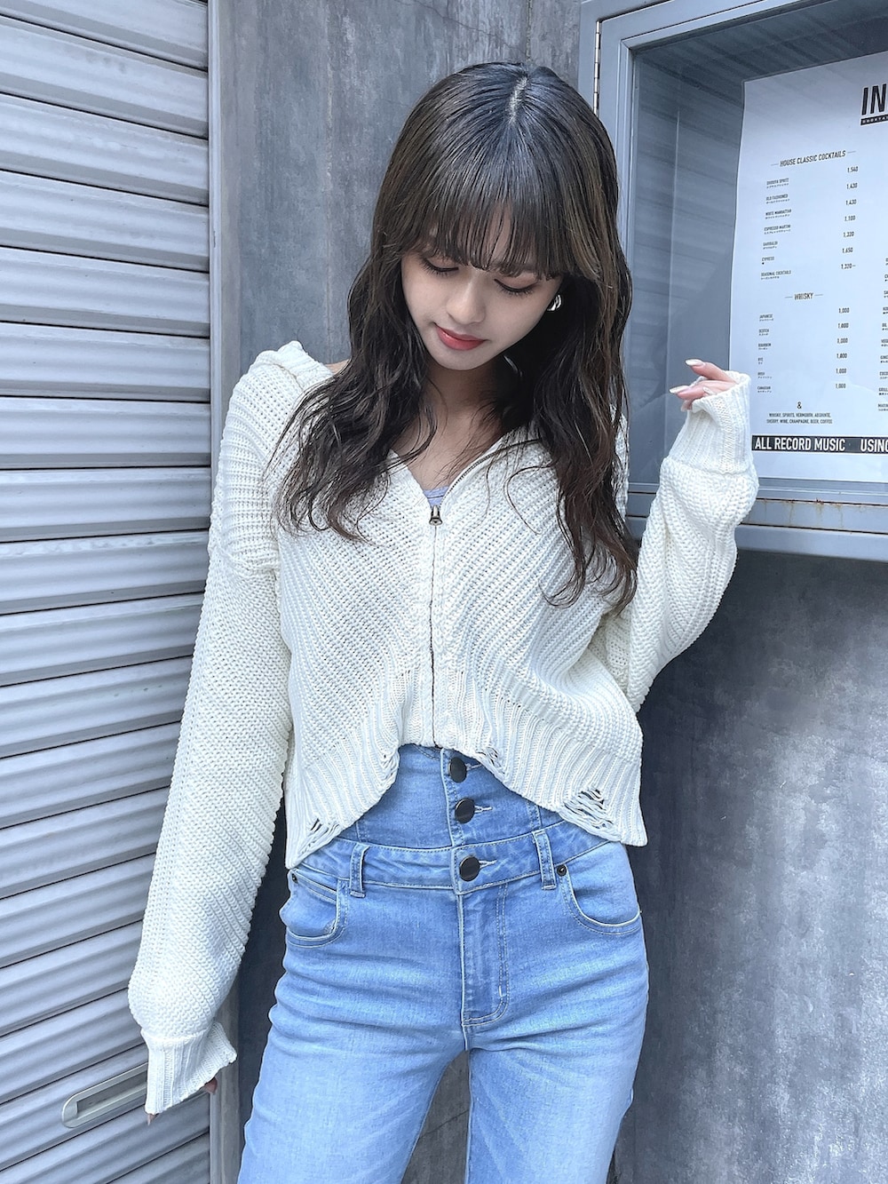 ホワイト系のニット/セーター、ブルー系のデニムパンツ、ベージュ系のブーツを着用したレディースの冬コーディネートの2枚目の写真