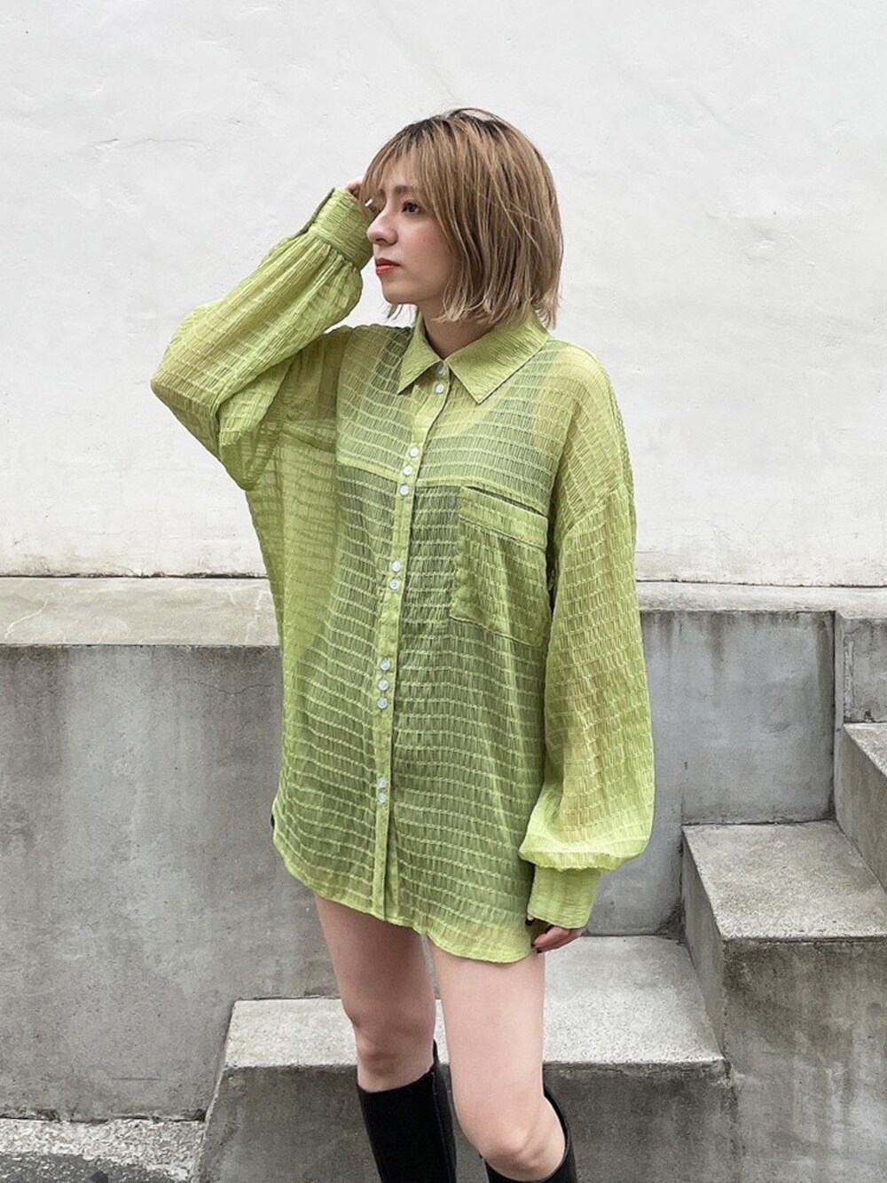 グリーン系のシャツ/ブラウス、ブラック系のブーツを着用したレディースの春コーディネートの3枚目の写真