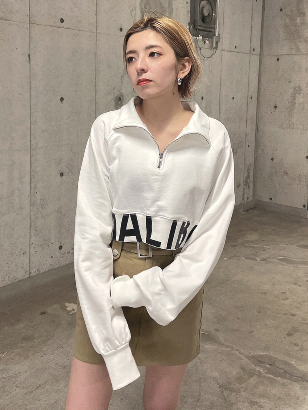 ホワイト系のTシャツ/カットソー、ベージュ系のスカート、ブラック系のブーツを着用したレディースの春コーディネートの4枚目の写真