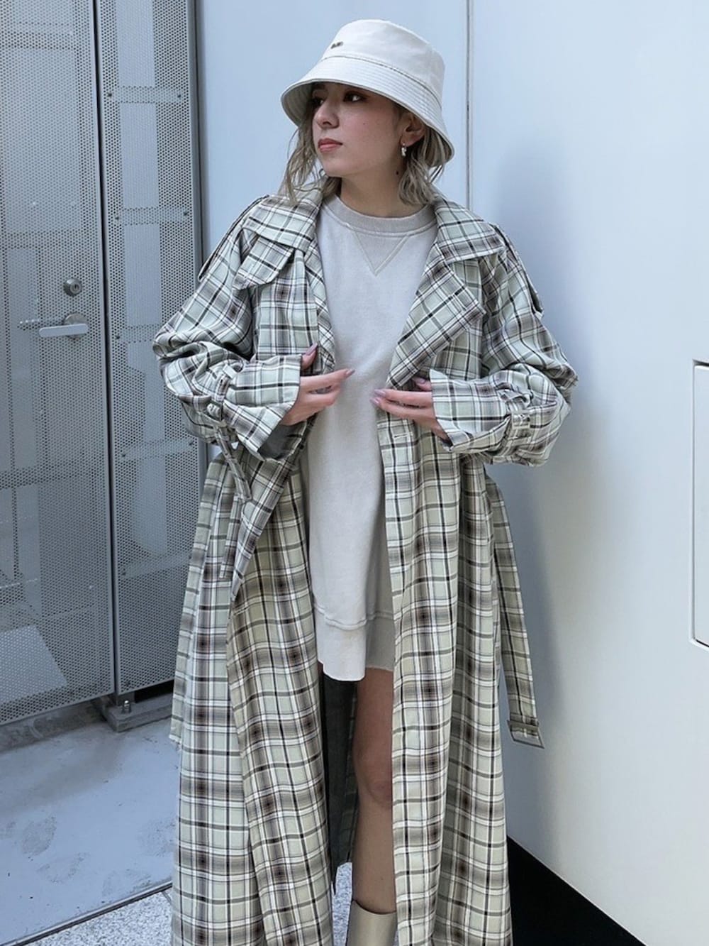 グレー系のスウェット、その他のトレンチコート、ホワイト系のブーツを着用したレディースの春コーディネートの2枚目の写真