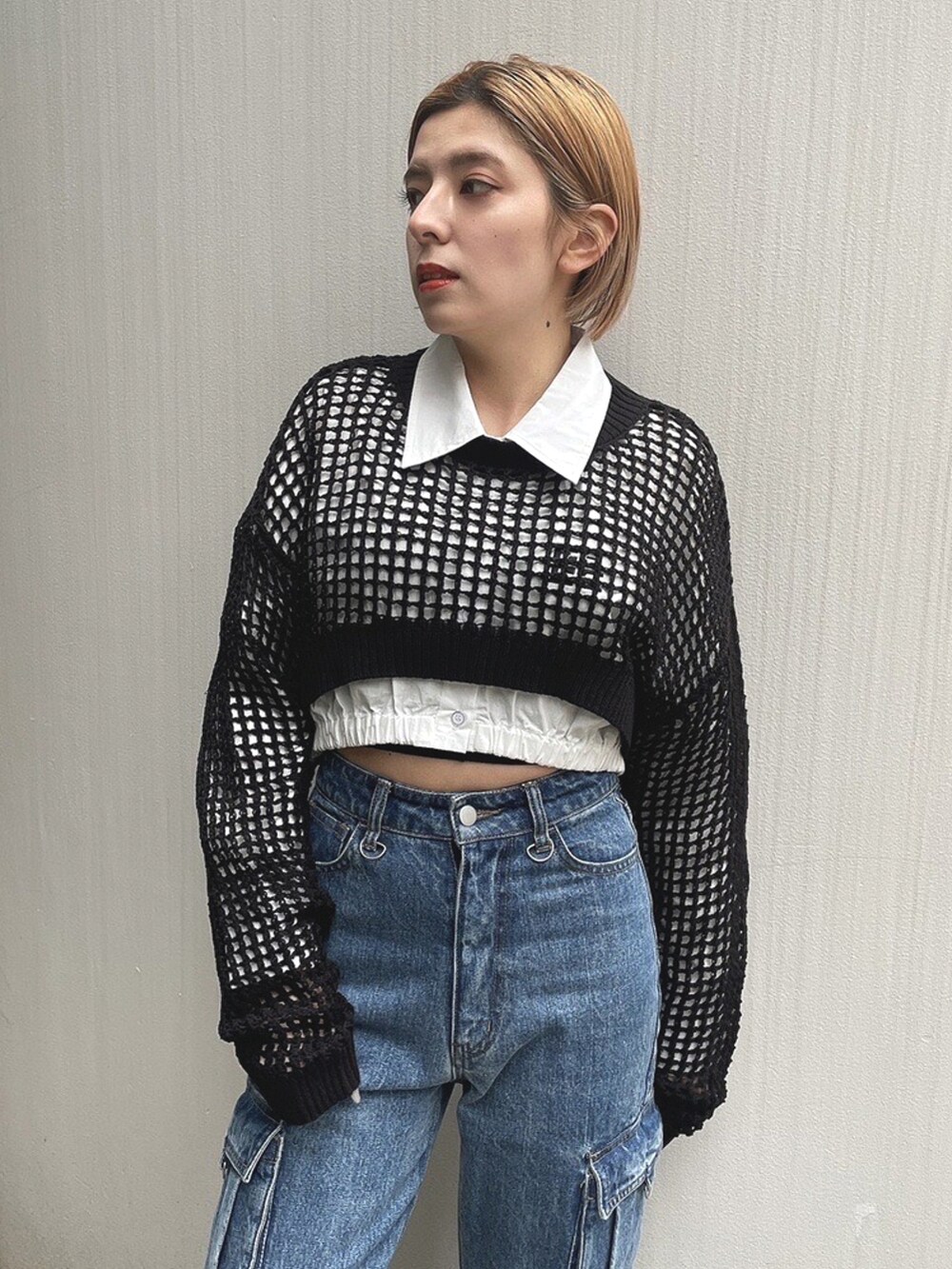 ホワイト系のシャツ/ブラウス、ブラック系のニット/セーター、ブルー系のデニムパンツを着用したレディースの春コーディネートの4枚目の写真